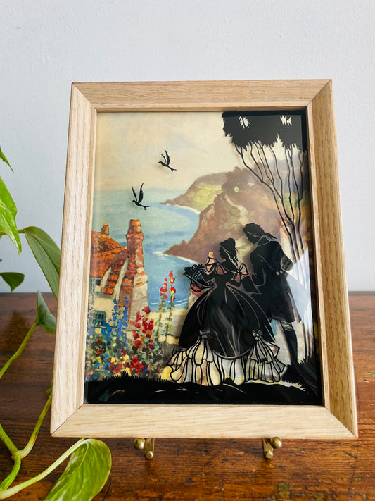 Reverse Painted Silhouette Lithograph Picture on Convex Bubble Glass - Courting Couple on Cliff with Seaside View